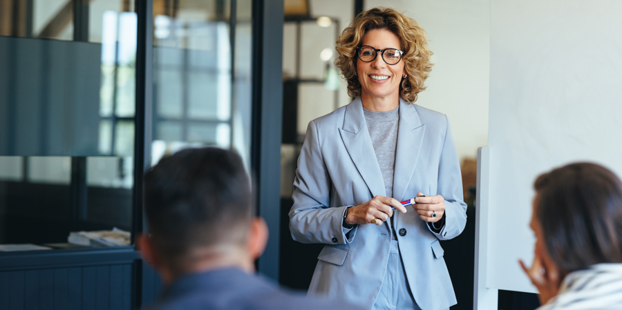 A woman giving a presentation to a group in a conference room